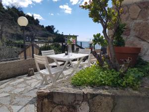 un tavolo bianco e sedie su un patio con un albero di Fulvia's cozy apartment with terrace a Monterosso al Mare