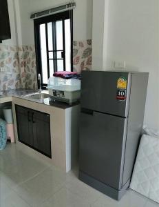 a kitchen with a refrigerator and a counter with a window at Na Na Twinhouse in Bang Tao Beach