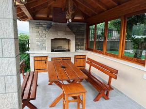 a patio with a wooden table and two benches at Apartments Ena in Trebinje