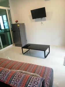 a living room with a tv and a bed in a room at Na Na Twinhouse in Bang Tao Beach