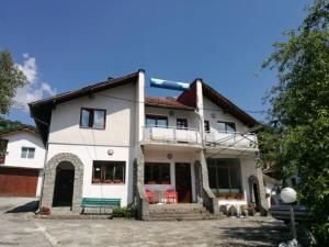 Cette grande maison blanche dispose d'un balcon. dans l'établissement Самостоятелни стаи в къща за гости Балкан, à Ribarica