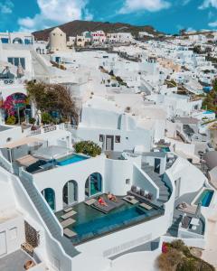 una vista aerea della città di Santorini con edifici bianchi di Echoes Luxury Suites a Oia