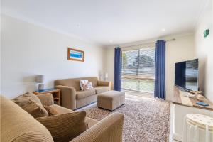 a living room with a couch and a tv at Happy Tails pet friendly air conditioned in Corlette