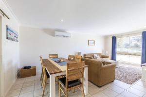 a living room with a dining room table and a couch at Happy Tails pet friendly air conditioned in Corlette