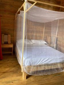 a bed with a canopy in a room at Bungalows Baobab in San Isidro de El General