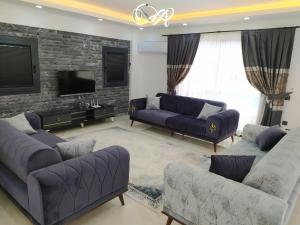 a living room with two couches and a tv at Villa KayaHan Göcek in Göcek