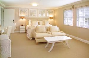 圣欧班La Place Country Cottages的一间卧室，里面有一张床、一张沙发和一张桌子