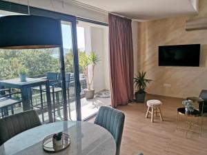 a living room with a dining table and a balcony at Apartmani Vito in Biograd na Moru