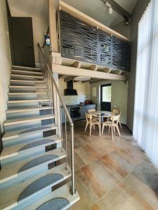a staircase in a room with a table and a kitchen at Kotedža “Saules osta” in Saulkrasti