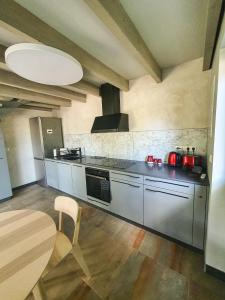 a kitchen with stainless steel appliances and a table at Kotedža “Saules osta” in Saulkrasti