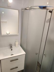 a bathroom with a sink and a shower with a mirror at MALTINA in Malbork