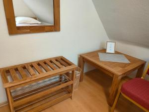 um pequeno quarto com uma mesa e um espelho em AM BERG Hotel em Herzberg am Harz