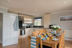 uma cozinha e sala de jantar com mesa e cadeiras em Fistral hot tub house for 8 on Retallack Resort em Newquay