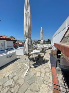 a patio with tables and umbrellas on a roof at Artemis Hotel Apartments in Keramoti