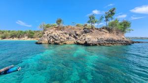 a person laying in the water near an island at Panorama Ekas in Ekas