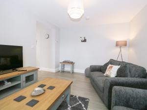 a living room with a couch and a tv at Oxen Park Farm Cottage in Ulverston