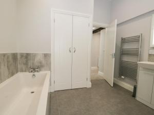 a white bathroom with a tub and a sink at Oxen Park Farm Cottage in Ulverston +19 photos