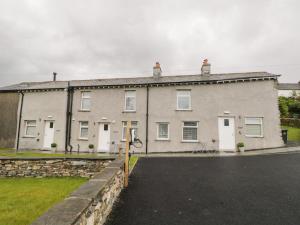 a large white building with a parking lot at Oxen Park Farm Cottage in Ulverston