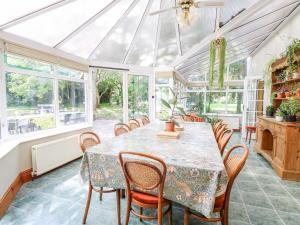a conservatory dining room with a table and chairs at The Firs in Wendling