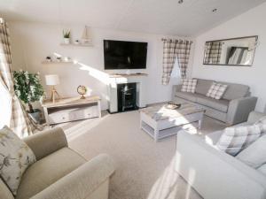 a living room with a couch and a tv at Rockpool Retreat in Saltburn-by-the-Sea