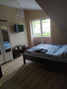 a bedroom with a bed and a large window at Sis Dziwnowek in Dziwnówek