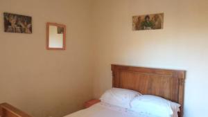 a bedroom with a bed and two pictures on the wall at Acomodação central e WI-FI in São Lourenço do Sul +5 photos