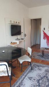 a living room with a desk with a television and chairs at Acomodação central e WI-FI in São Lourenço do Sul