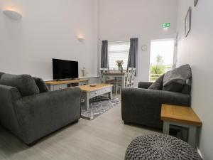 a living room with two couches and a tv at Mollys Pantry in Ulverston