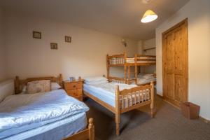 una camera con 2 letti e un letto a castello di The Holmes Barn - Sleeps 16 - Peak district a Buxton