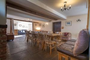 una sala da pranzo con tavolo e sedie di The Holmes Barn - Sleeps 16 - Peak district a Buxton