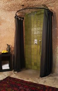 a bathroom with a shower with green tiles at SOTA Cappadocia in Ürgüp