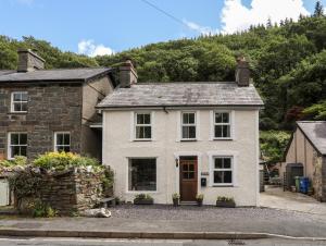 Casa blanca con un edificio de piedra en Llys Elen, en Caernarfon