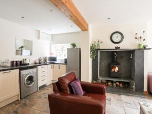 a kitchen with a couch and a fireplace in a room at Llys Elen in Caernarfon