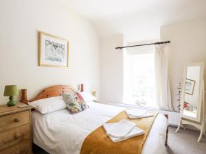 Un dormitorio con una cama y una cómoda y una ventana. en Llys Elen, en Caernarfon