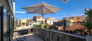 een patio met een parasol op een balkon bij Loveroom La Garçonn'Hyeres in Hyères
