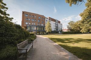 un parque con un banco frente a un edificio en Avenue Pallova 28, en Plzeň