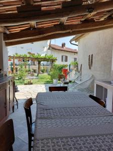 Zimmer mit einem Tisch und Stühlen sowie einer Terrasse in der Unterkunft Casa di campagna Il melo tra vigne e noccioli. in Cigliè