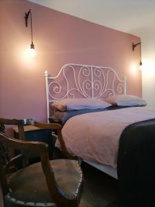 ein Schlafzimmer mit einem Bett, einem Tisch und einem Stuhl in der Unterkunft Casa di campagna Il melo tra vigne e noccioli. in Cigliè