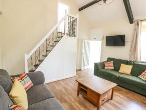 a living room with a couch and a table at Y Bwthyn Bach in Bangor