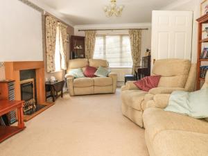 sala de estar con sofá y silla en Birdsong, en Crediton