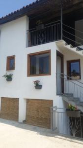 ein weißes Gebäude mit Topfpflanzen auf den Balkonen in der Unterkunft Casa di campagna Il melo tra vigne e noccioli. in Cigliè