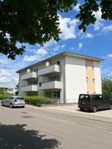 a building with two cars parked in front of it at Business Apartment Reutlingen in Reutlingen