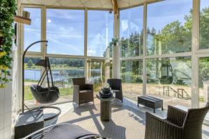 eine abgeschirmte Veranda mit Stühlen und einer Schaukel in der Unterkunft VVF Corrèze Pays d'Eygurande in Eygurande