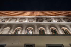 un bâtiment avec des arches sur son côté dans l'établissement Palazzo Portinari Salviati Residenza D'Epoca, à Florence