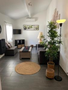een woonkamer met een bank en een tafel bij Maison avec jardin à 8 min de l'aéroport in Saint-Victoret