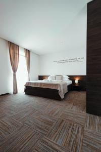 a bedroom with a bed and a wooden floor at Hotel Emporium in Bihać
