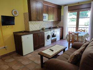 a living room with a couch and a kitchen at Apartamentos Rurales La Viña in Cangas de Onís