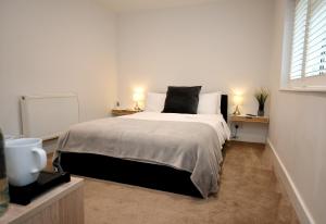 a bedroom with a large bed with two night stands at Apple Tree Place B&B in Tadley