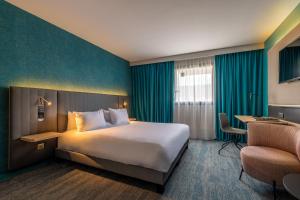 a hotel room with a bed and a desk and a chair at Holiday Inn Reims Centre, an IHG Hotel in Reims