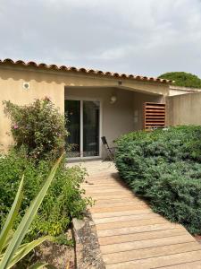 a wooden walkway in front of a house at Les Jardins De Santa Giulia - Charmante chambre dhte 1 in Porto-Vecchio +15 photos